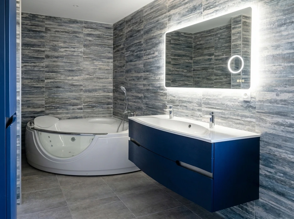 Salle de bain moderne avec baignoire d'angle balnéothérapie blanche, meuble vasque double suspendu bleu marine avec plan vasque intégré blanc, robinetterie chromée monotrou