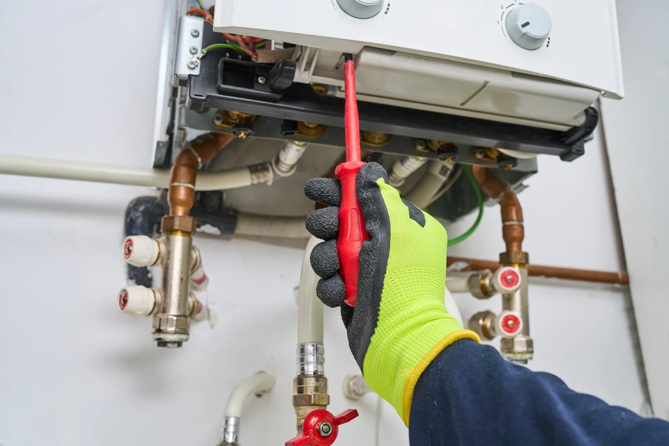Local technique intérieur avec installation de pompe à chaleur air/eau **Mitsubishi Ecodan** montée en mural, réseau de tuyauterie en cuivre, vase d'expansion, groupe hydraulique avec manomètres, ballon tampon au sol et ballon d'eau chaude sanitaire **Romaero** mural